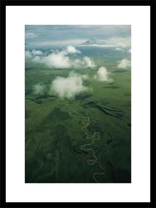 A river snakes across the tundra toward distant Mount Shishaldin