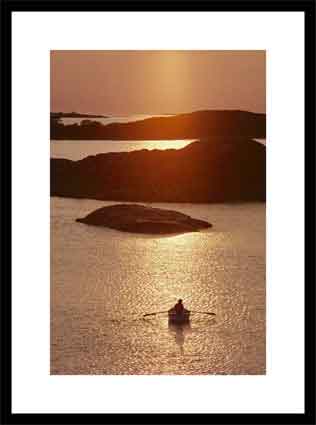 Rowboat heads toward a series of low-lying islands at twilight